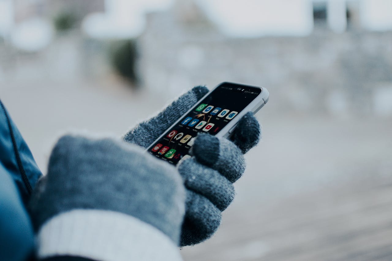 Person Wearing Gloves Holding a Cellphone